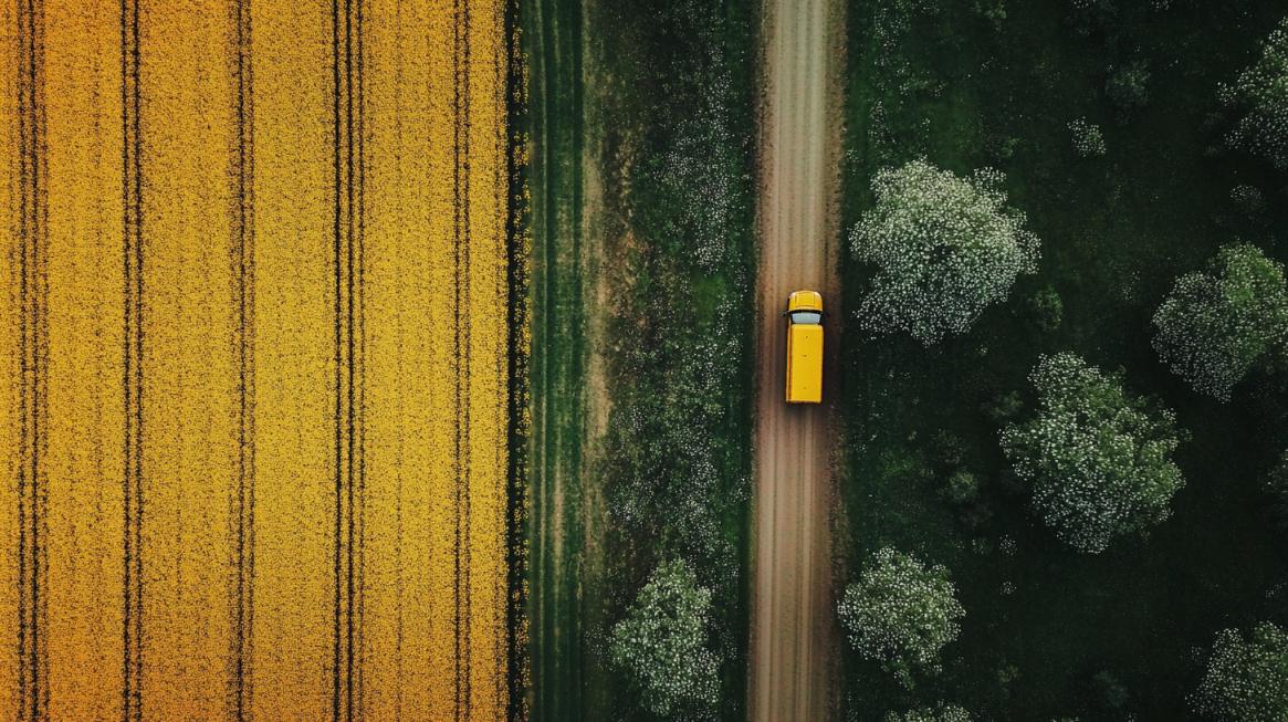 Aerial view of agricultural freight moving beside cultivated fields